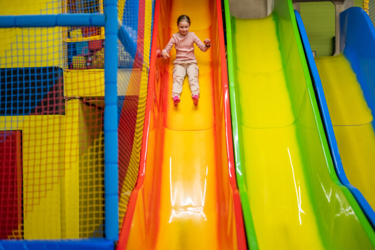 Colorful indoor playground with slides and tunnels.
